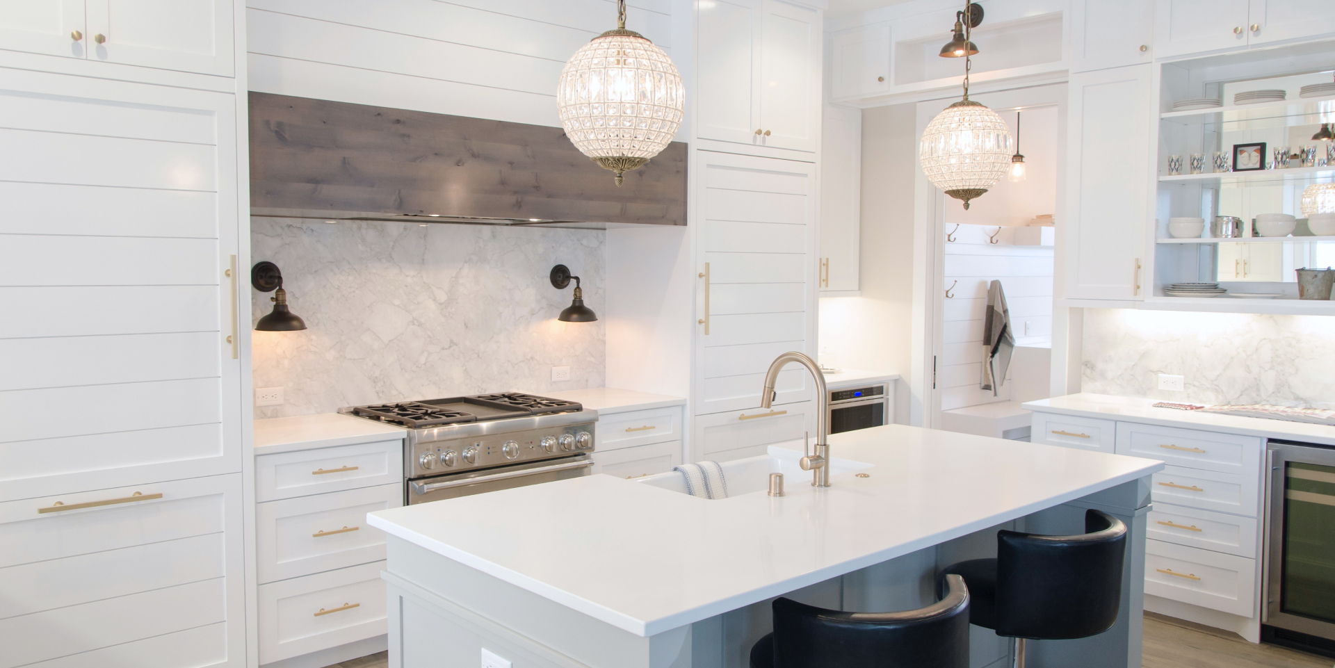 Bright kitchen with marble backsplash and crystal pendants
